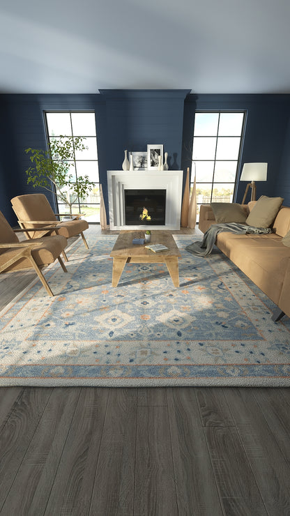 Cozy modern living room with navy walls, white fireplace, tan sofa and lounge chairs, glass coffee table, blue patterned rug.