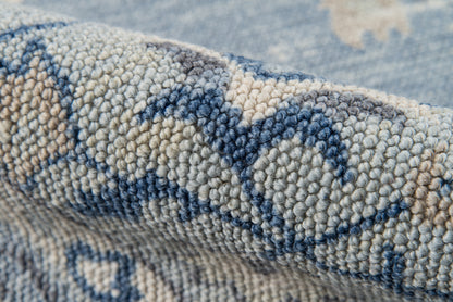 Close-up of a blue and beige woven rug with chunky loop pile and geometric motif.