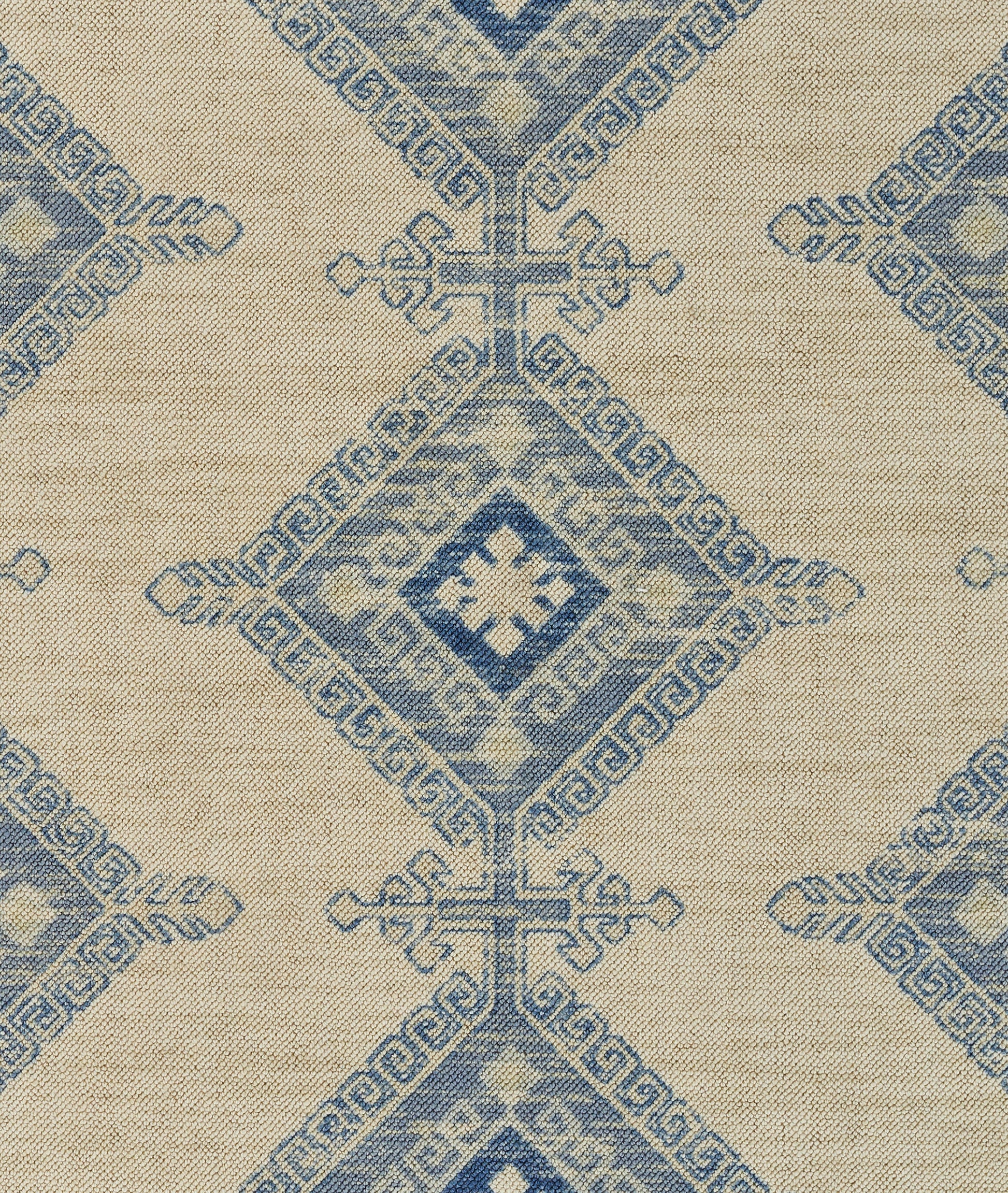 Beige rug with a repeating blue diamond medallion pattern; vintage-inspired design.