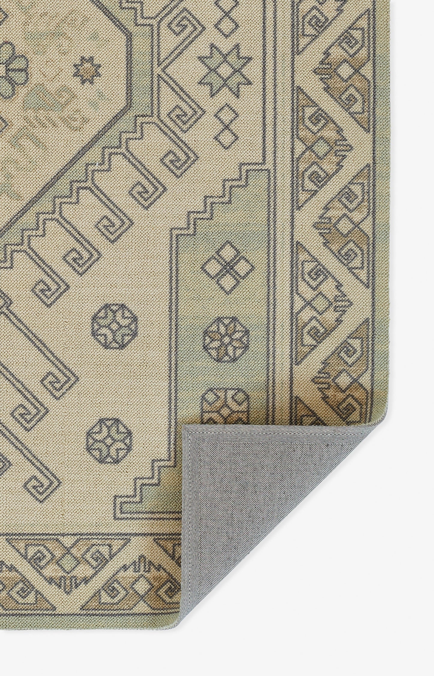 Beige geometric rug with grey-brown outlining, Greek-key borders; folded corner shows backing.