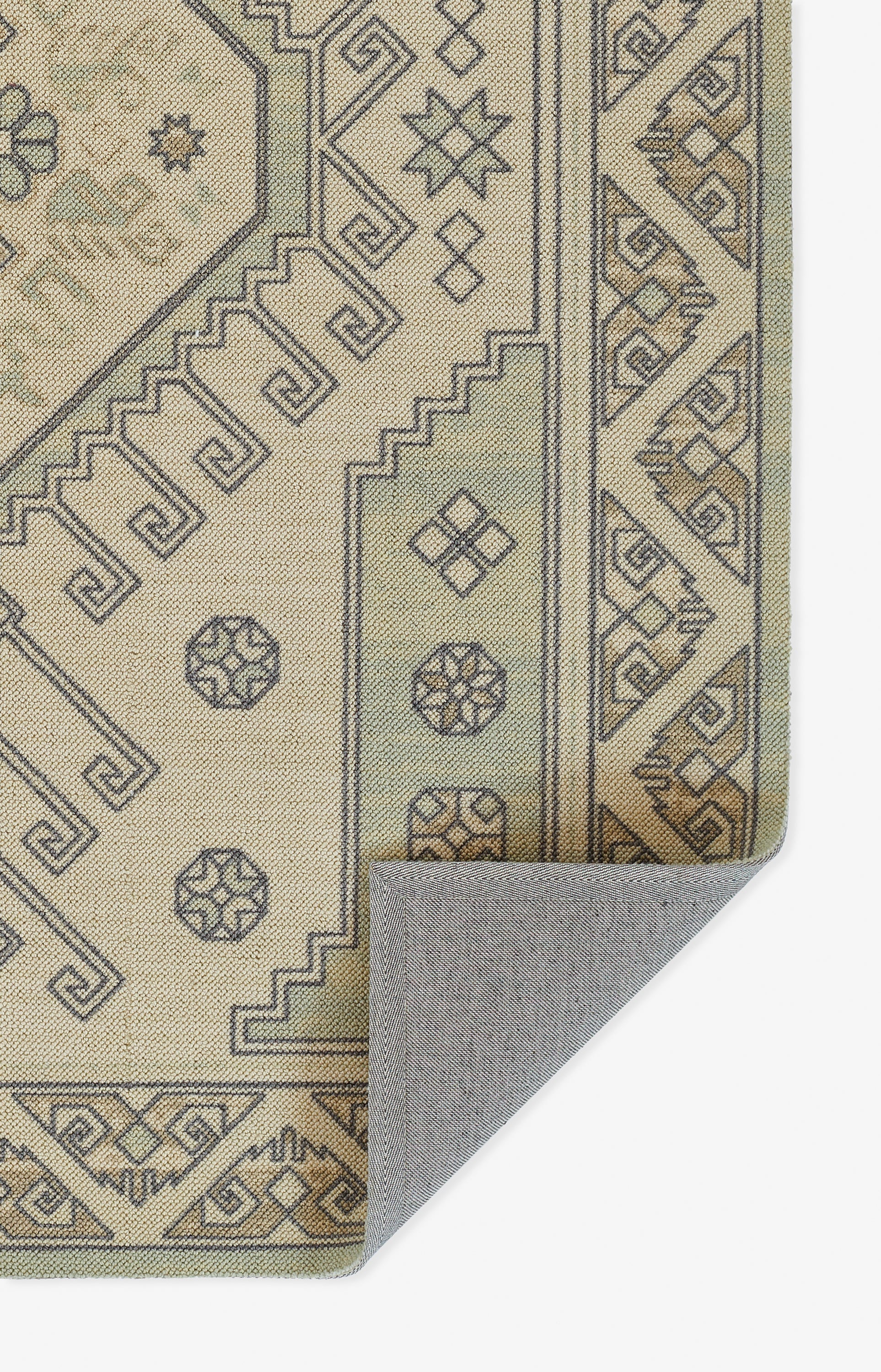 Beige geometric rug with grey-brown outlining, Greek-key borders; folded corner shows backing.