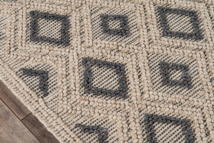 Beige geometric rug with dark gray diamond motifs and raised loop texture on wood floor.