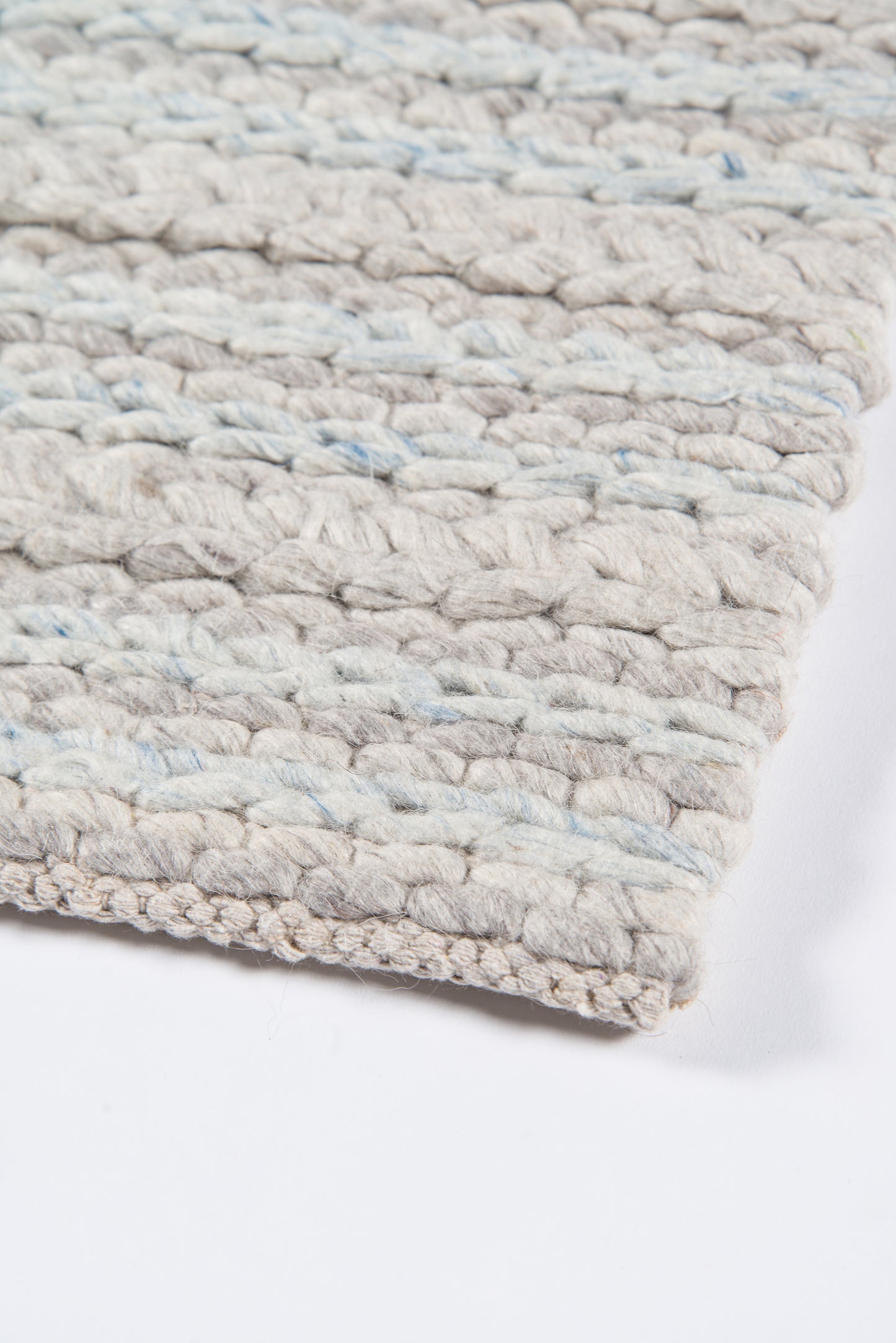 Beige chunky boucle woven rug with pale blue specks; textured rectangular rug for cozy living spaces.