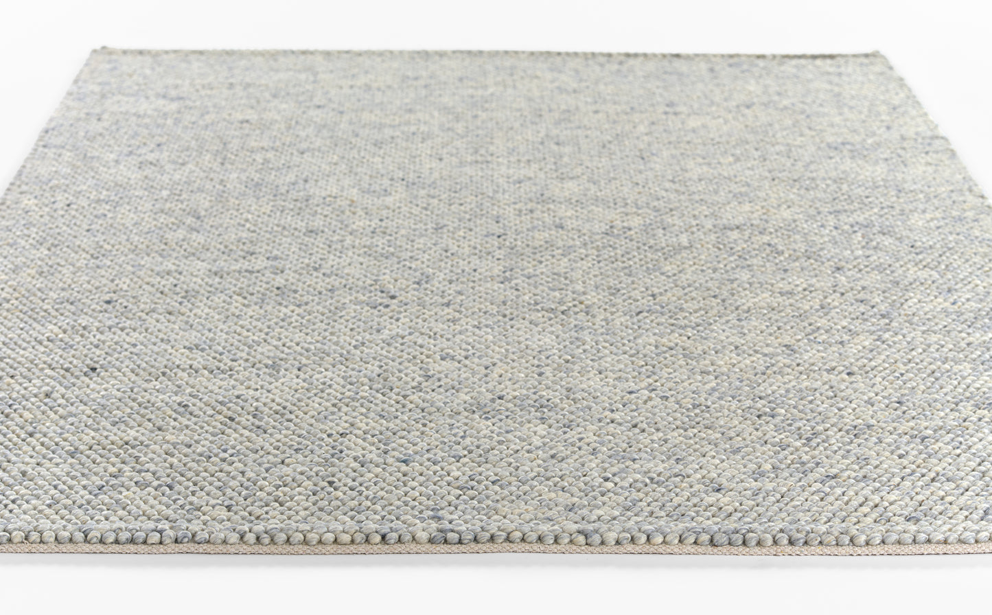 Bluish-gray flatweave rug with speckled texture and knotted fringe along the edge.