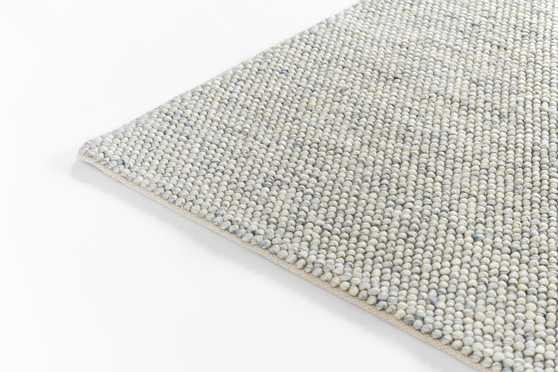 Rectangular woven rug in light blue-gray and sand tones with a tight loop texture.