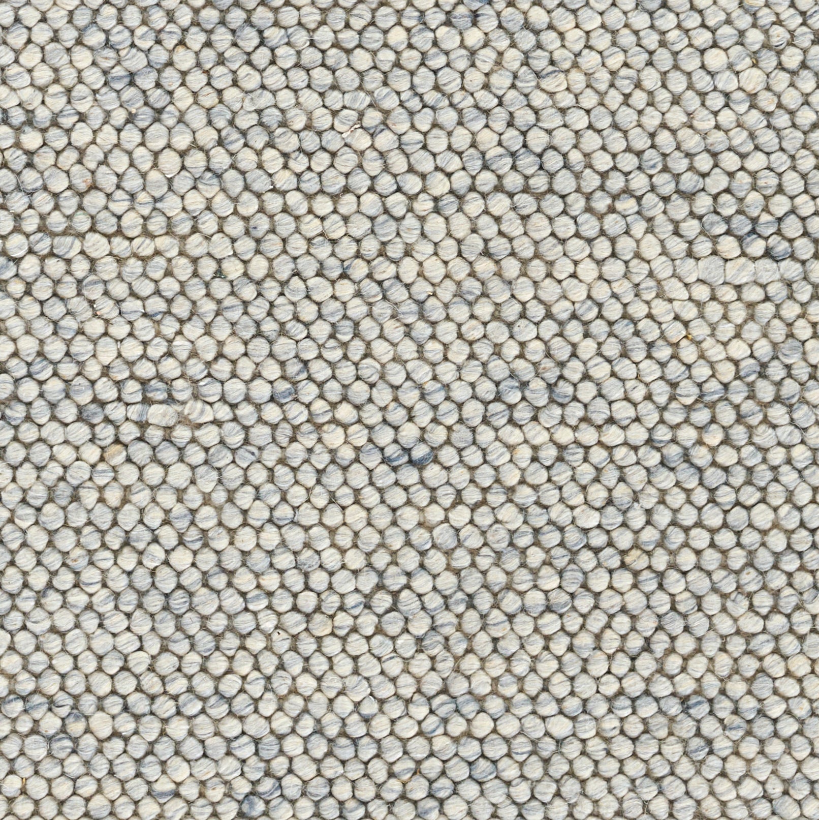 Close-up of a speckled beige-gray-blue loop-pile rug with tiny pebble-like fibers.
