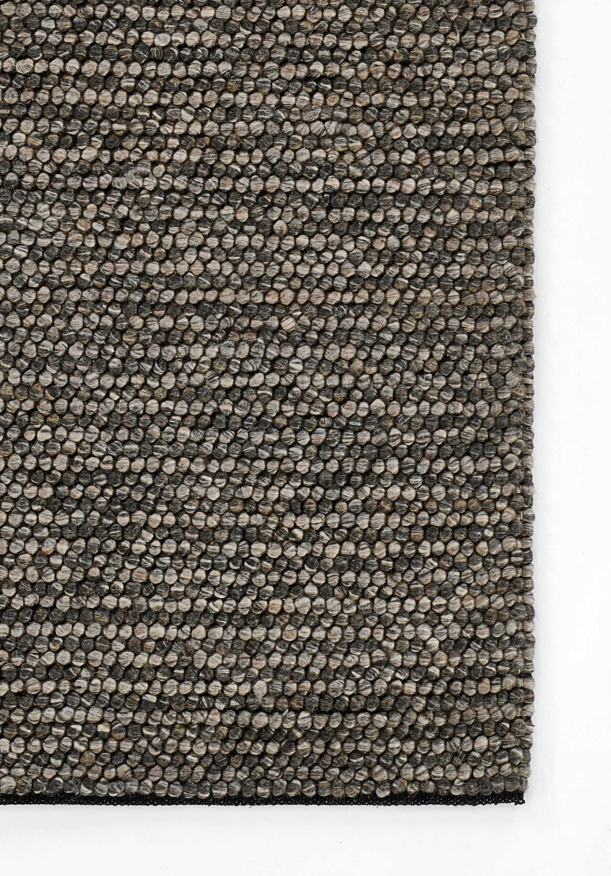 Close-up of a rectangular taupe-gray loop-pile rug with tight speckled texture and dark border