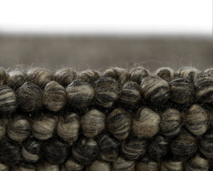 Dark brown and charcoal chunky boucle rug close-up with thick twisted loops.