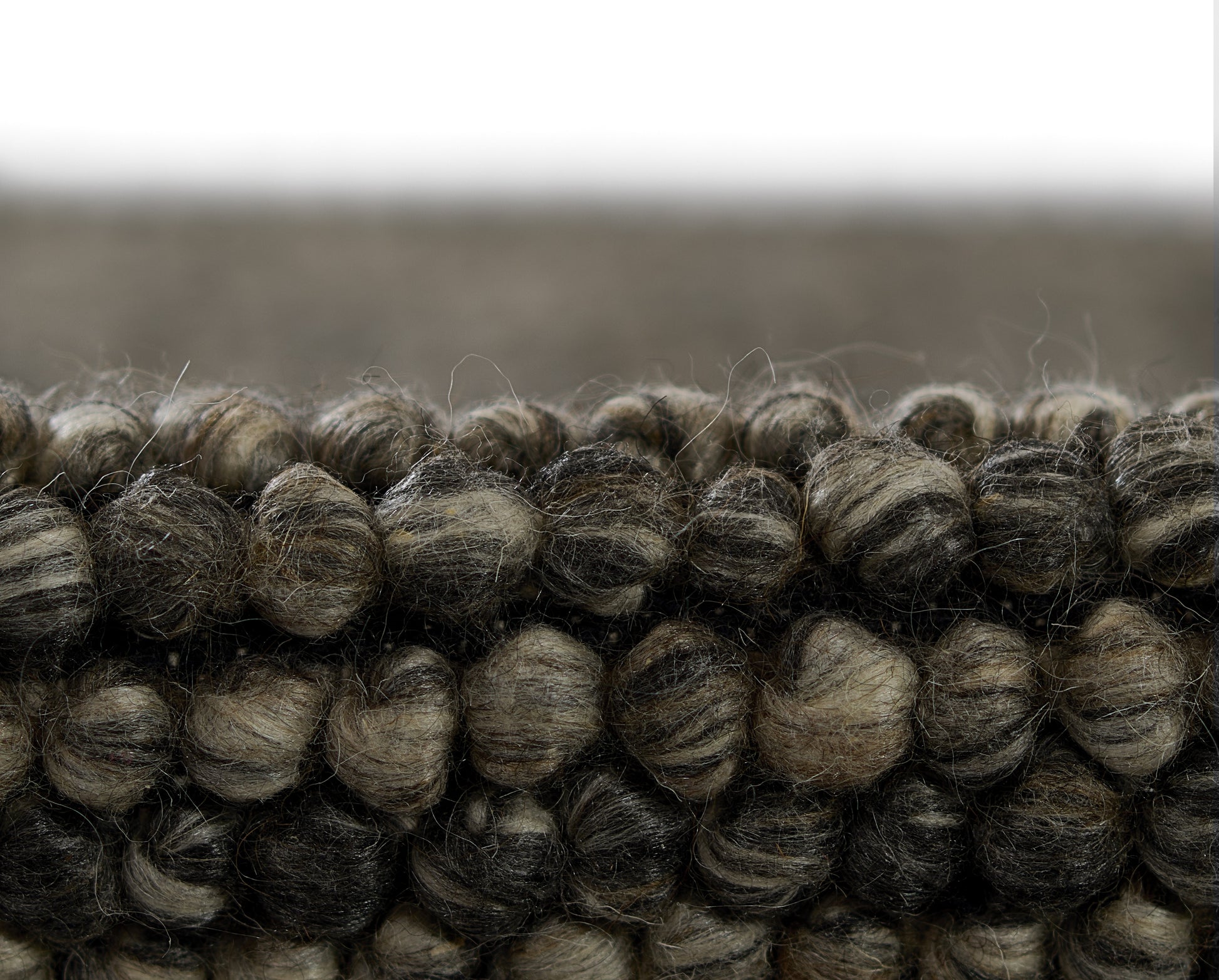 Chunky looped wool rug in charcoal, brown and taupe tones; plush textured weave.