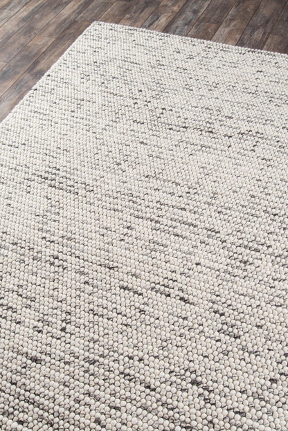Rectangular ivory woven rug with chunky loop texture and subtle beige-grey geometric pattern.