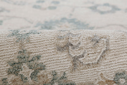 Close-up of a beige woven rug with blue floral medallion pattern and soft textured pile.