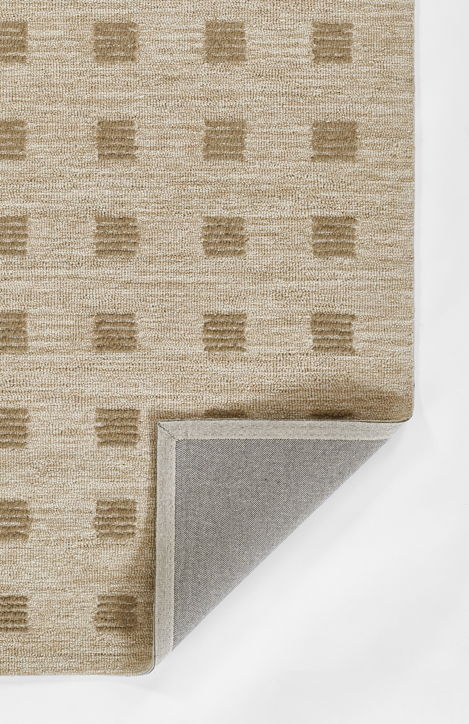 Beige textured woven rug with tan square grid pattern; folded corner shows gray backing.