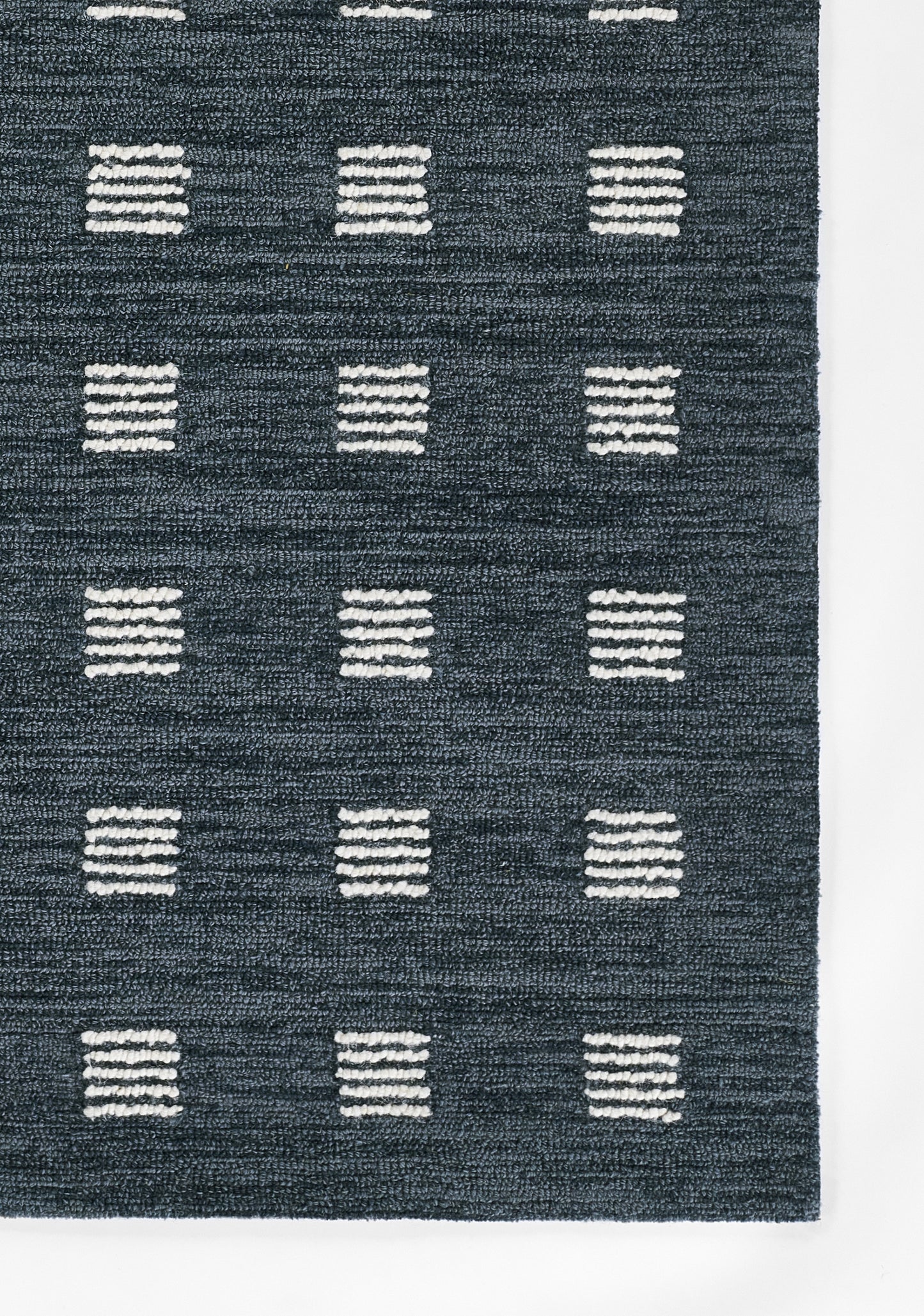 Dark blue rug with white striped squares arranged in a grid pattern.