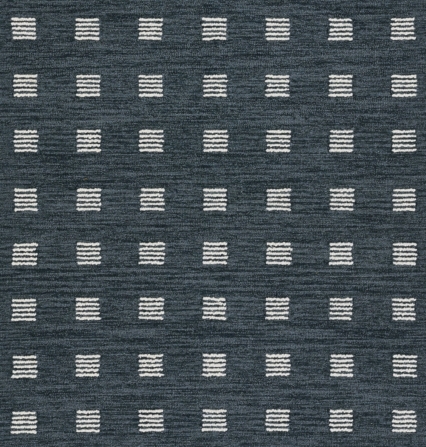 Navy blue rug featuring a grid of small white stitched square blocks in a geometric, modern design.