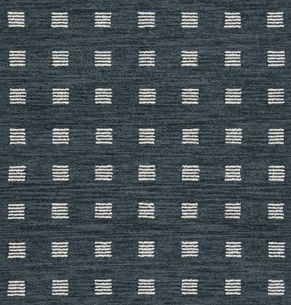 Navy blue rug featuring a grid of small white stitched square blocks in a geometric, modern design.