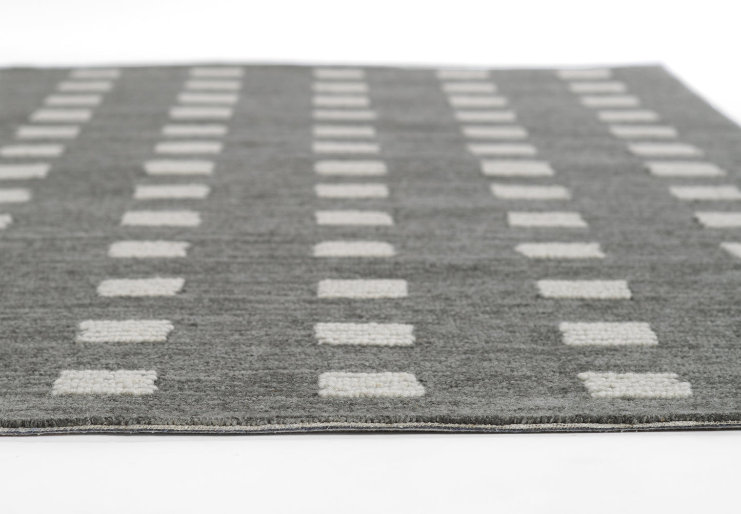 Charcoal gray rug with cream rectangular grid pattern; flat-weave, modern geometric style for living room floors.