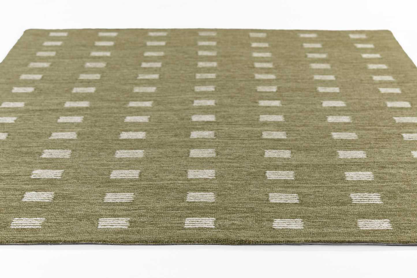 Olive green area rug with white rectangular dots in a neat grid; modern geometric mid-century style.