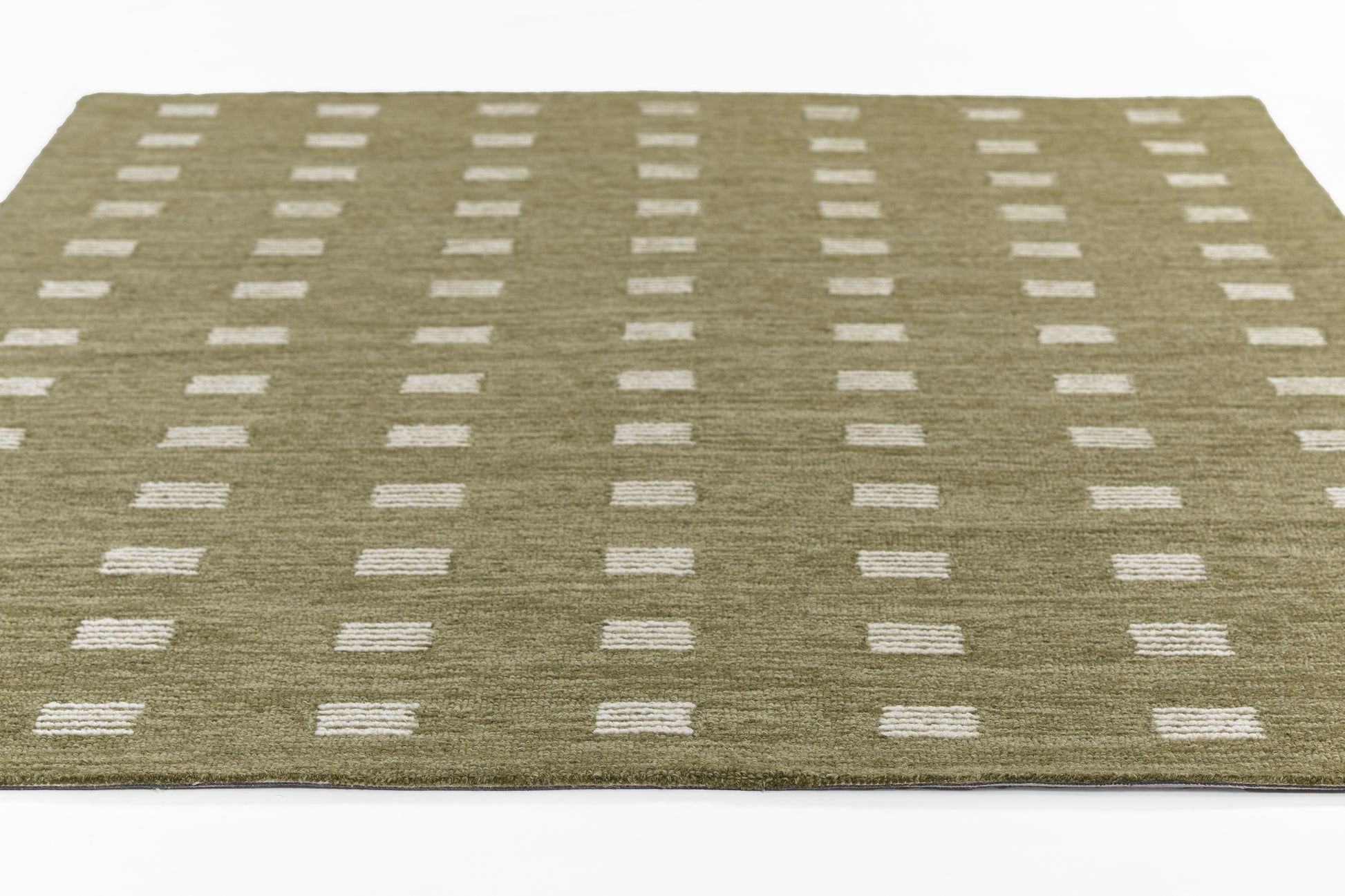 Olive green area rug with white rectangular dots in a neat grid; modern geometric mid-century style.