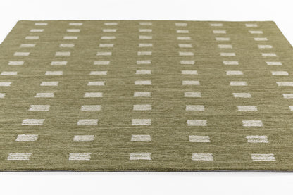 Olive green area rug with white rectangular dots in a neat grid; modern geometric mid-century style.