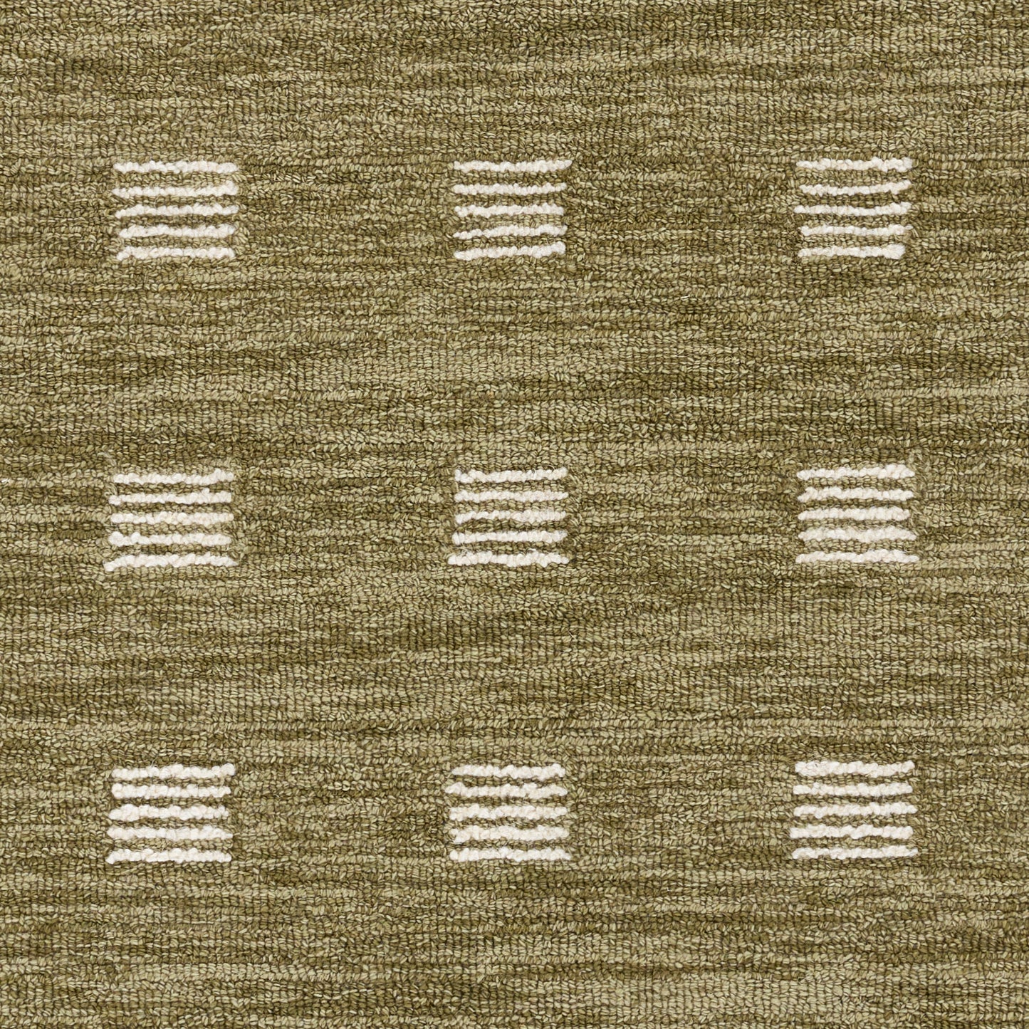 Olive-brown woven rug with ivory square dash motifs in a subtle grid pattern.