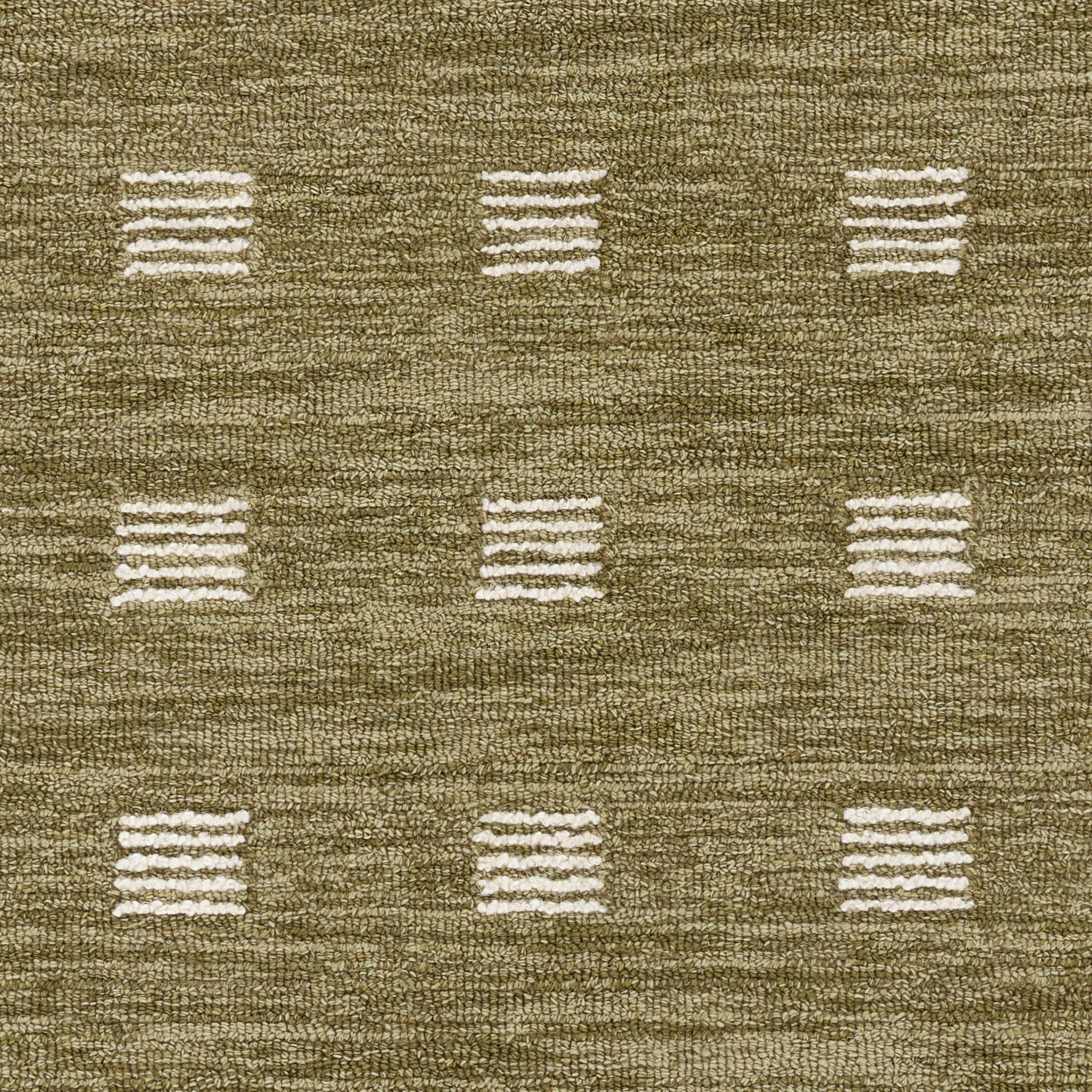 Olive-brown woven rug with ivory square dash motifs in a subtle grid pattern.