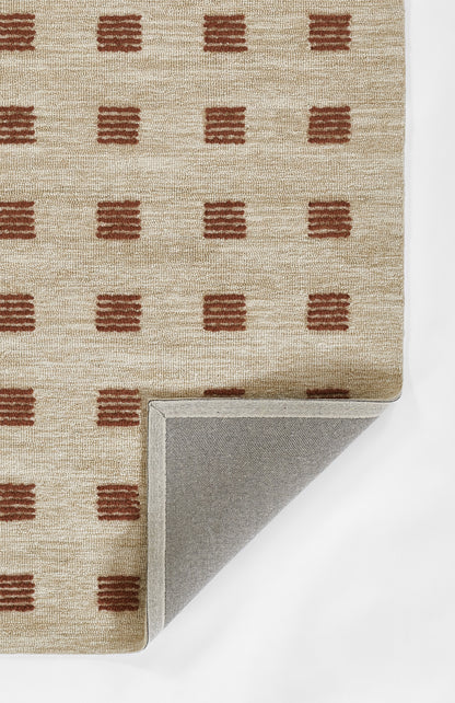 Beige woven rug with rust rectangular dash motifs; folded corner shows light gray backing.