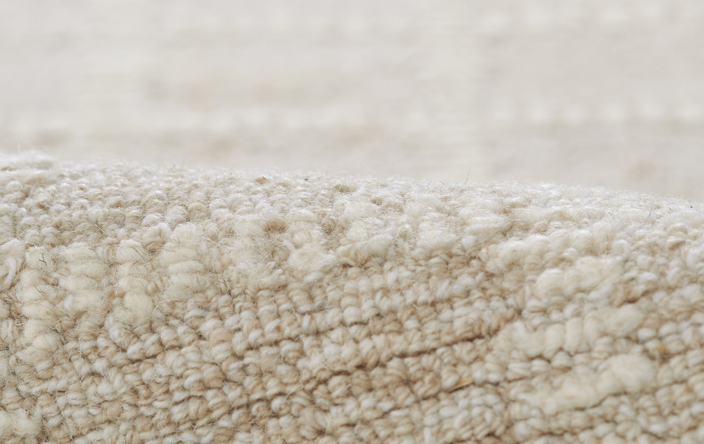 Close-up of cream-beige carpet fibers with a soft, plush, textured pile.