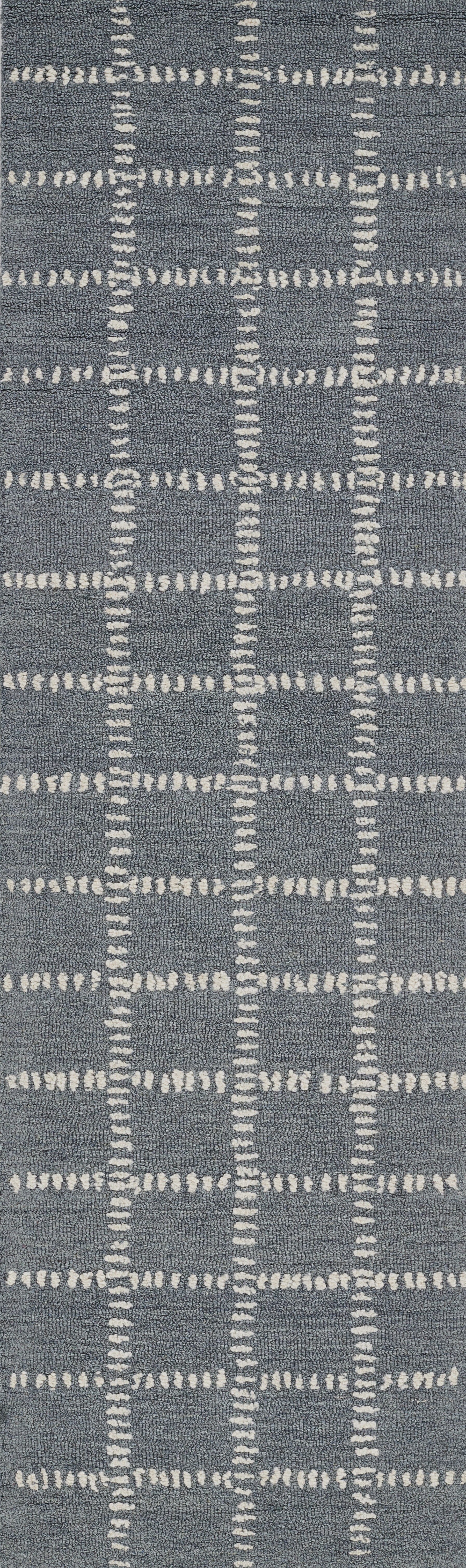 Blue-gray rug with white dashed grid lines forming a geometric plaid pattern.