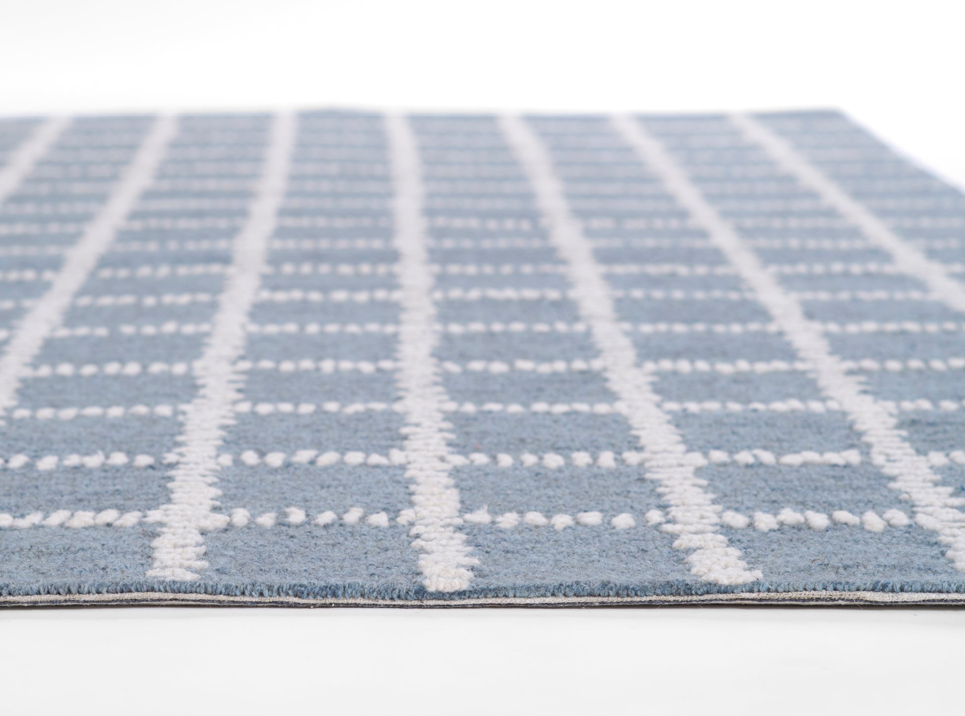 Blue rug with white vertical & horizontal grid lines in a soft textured weave; rectangular, modern plaid style.