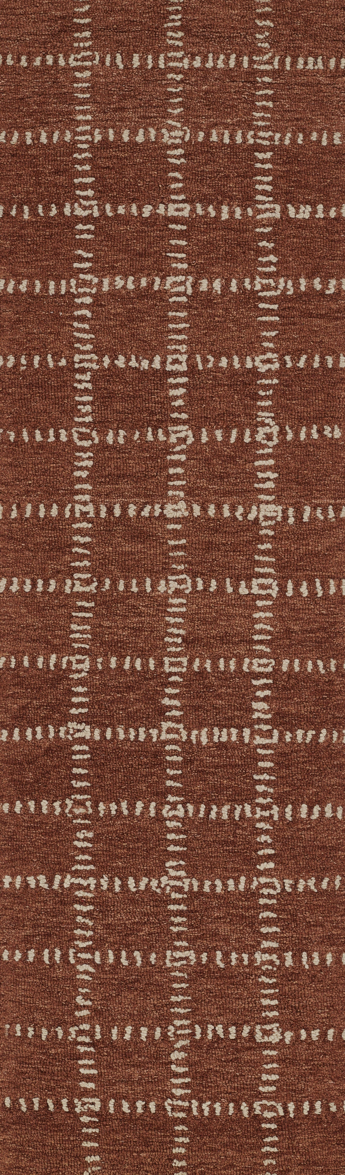 Rust red woven area rug with white dashed grid forming square blocks; textured, rustic finish.