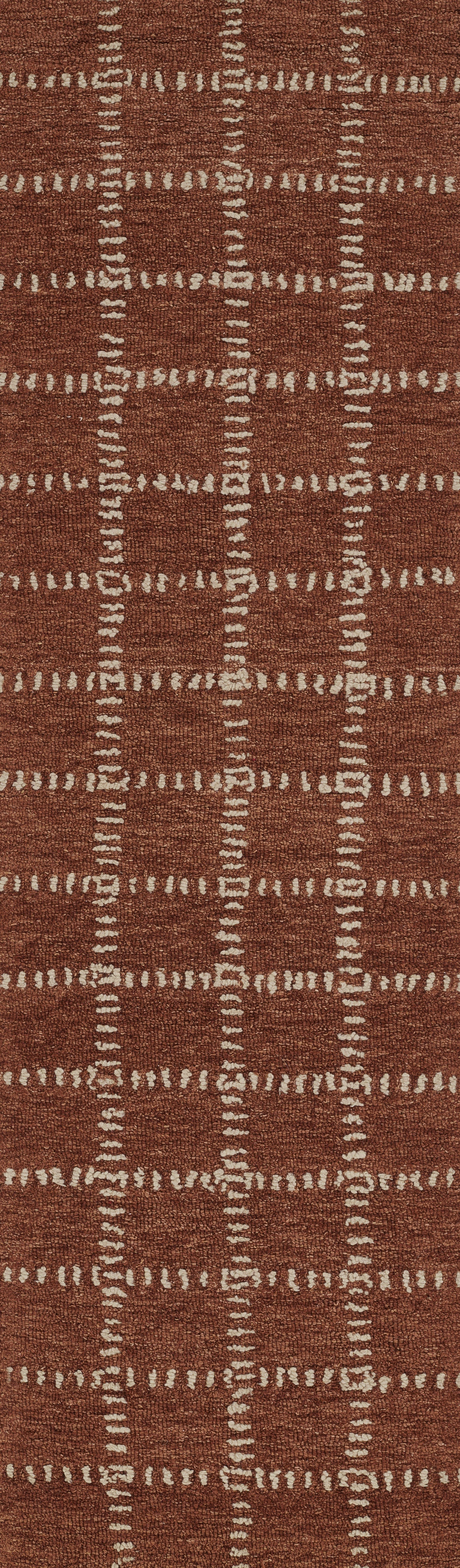 Rust red woven area rug with white dashed grid forming square blocks; textured, rustic finish.