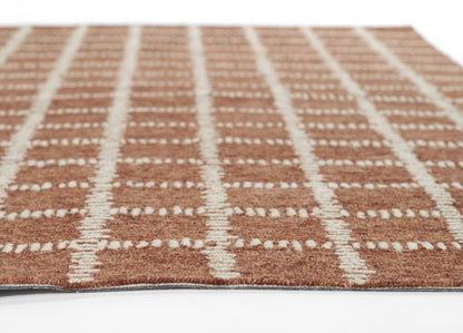 Brown rectangular shag rug with cream white grid lines; plush pile and visible edge.