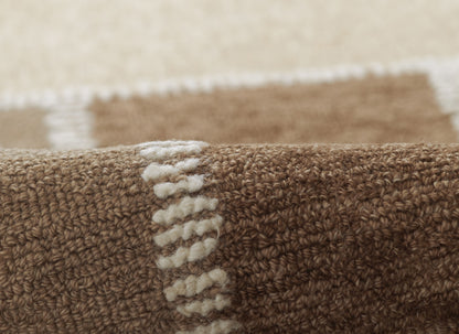 Brown textured rug with cream vertical loop pattern; plush woven pile in warm neutral tones.