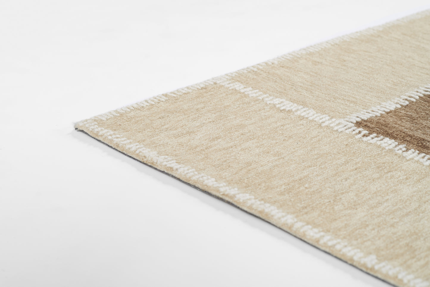 Beige patchwork runner rug with white stitched border and brown patch, soft pile for living room decor.