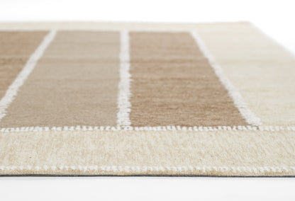 Geometric beige and taupe rug with white dividing lines forming rectangular panels; plush pile.