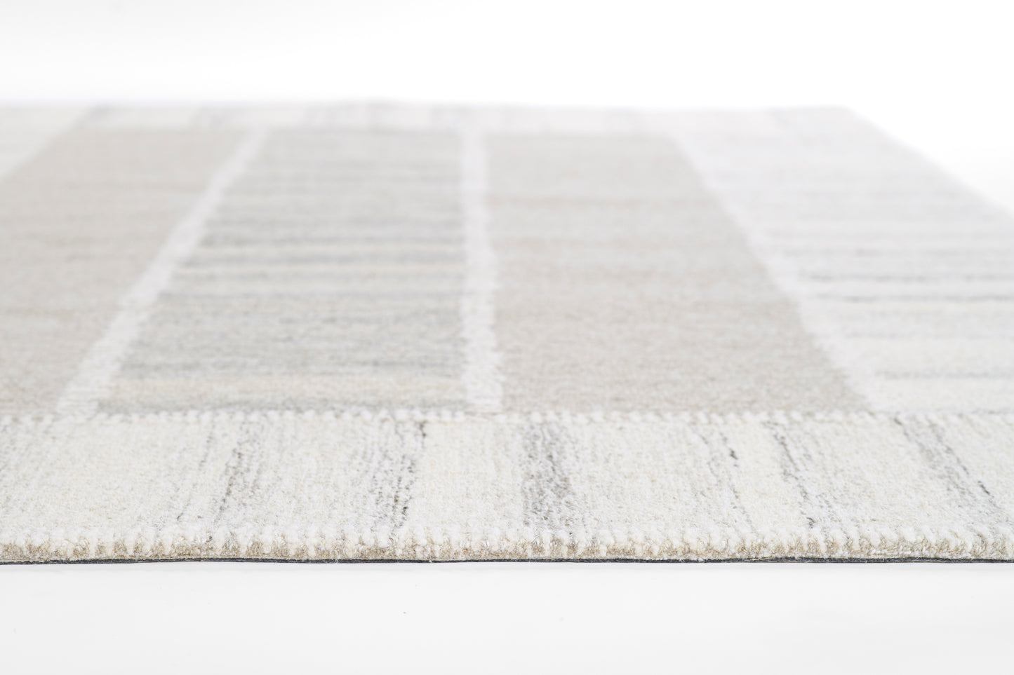 Light gray & beige patchwork area rug with a soft textured pile; rectangular block design.