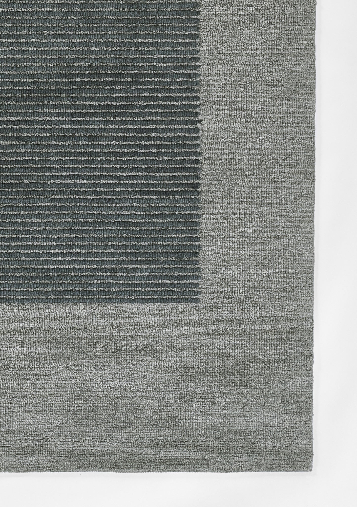 Blue-gray textured area rug with a darker rectangular inset and light gray border, woven pile.