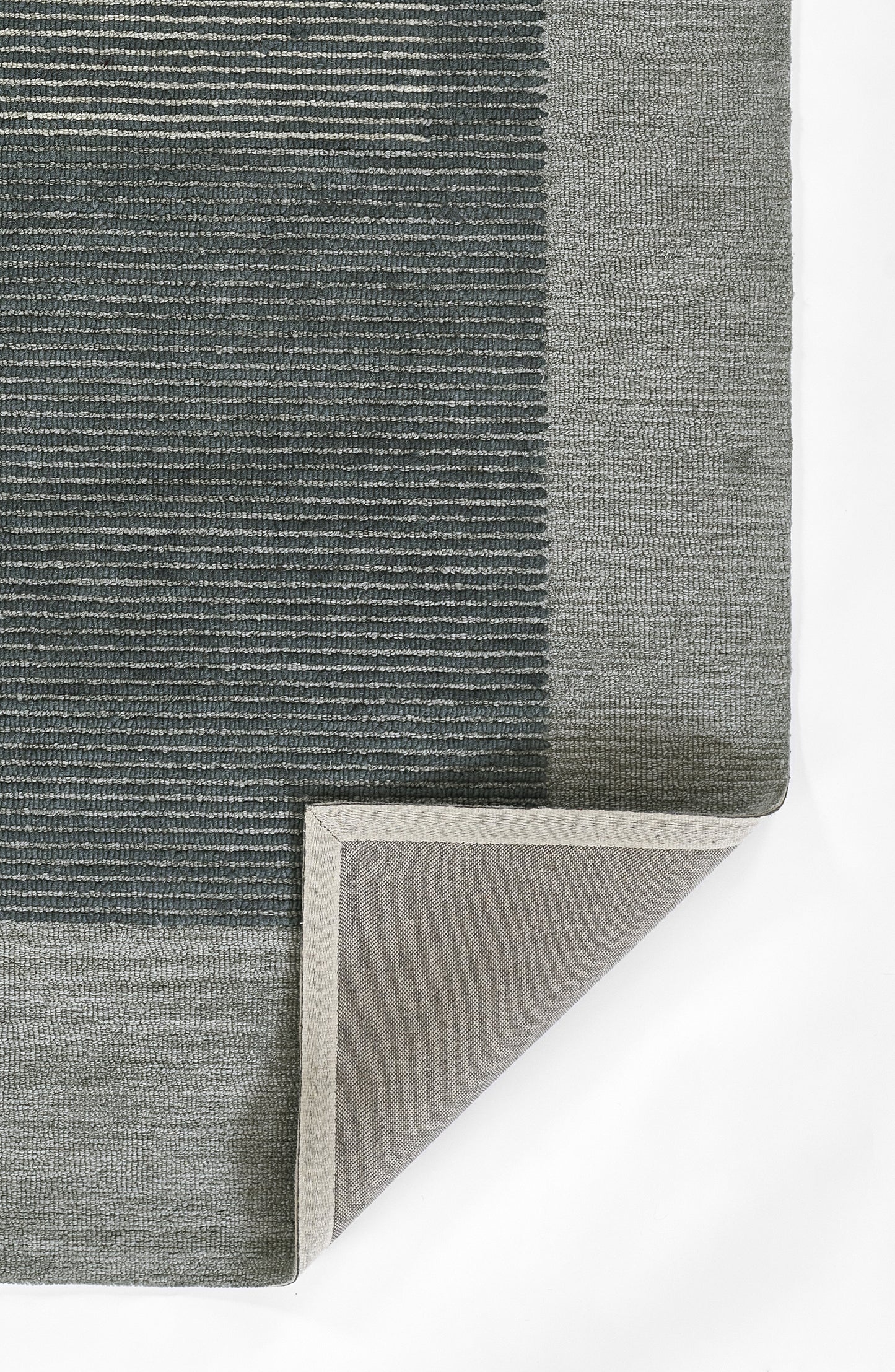 Blue-gray woven area rug with light gray border; textured striped pattern, corner folded to reveal underside.
