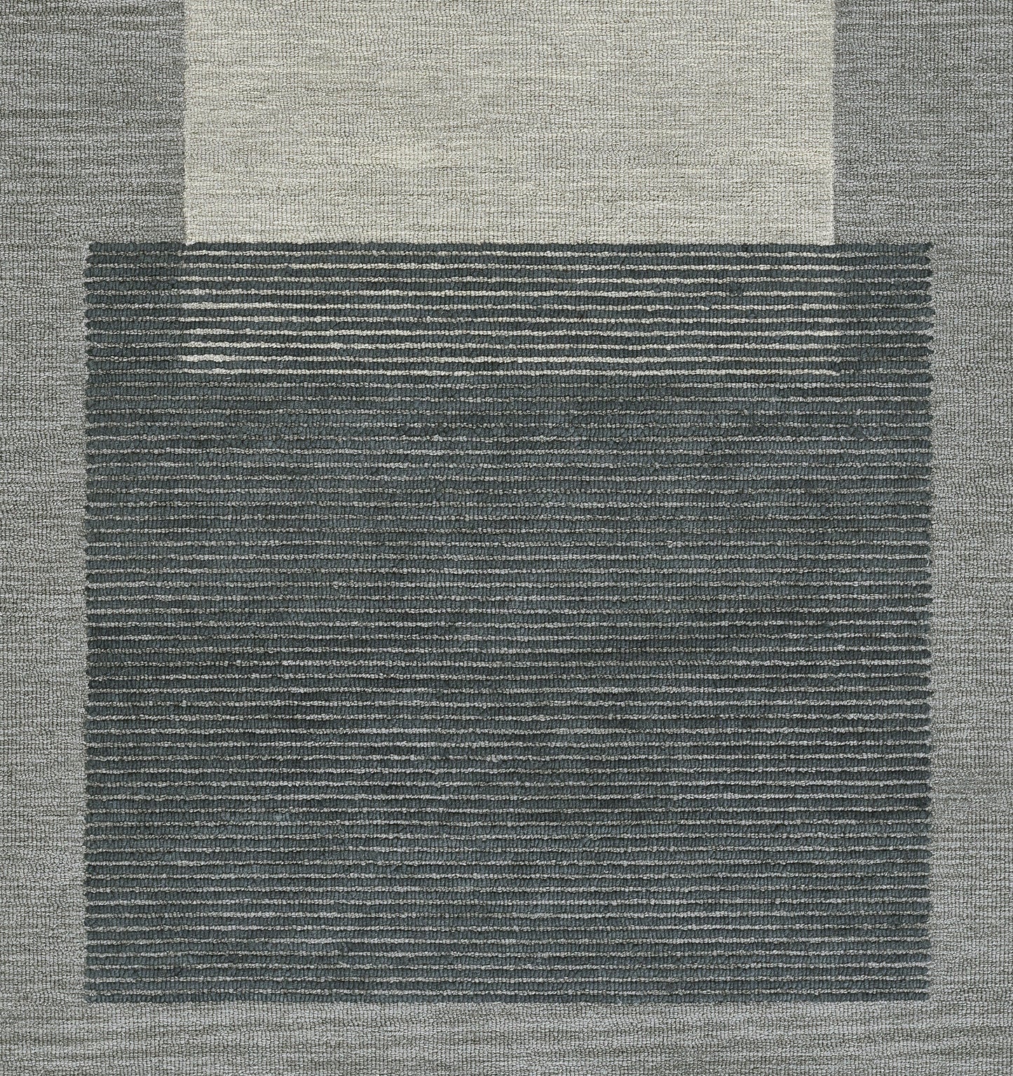 Blue-gray area rug with a dark striped central panel and light beige outer border; modern geometric, textured weave.