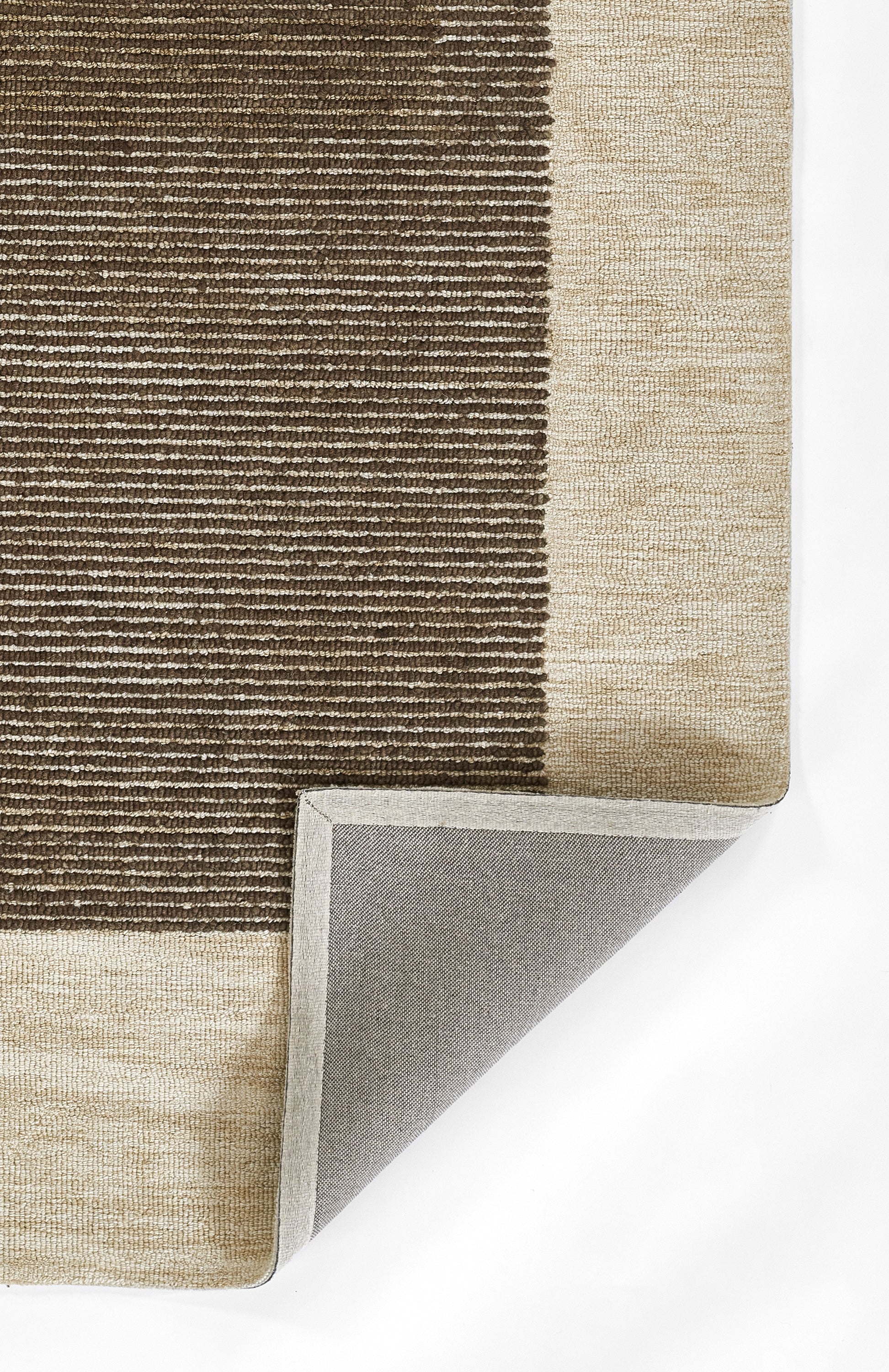 Rectangular area rug with brown and beige striped pattern, woven texture, light beige border, folded corner shows gray backing.
