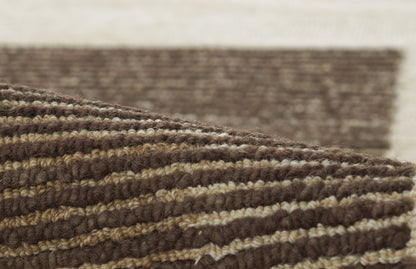 Brown and beige striped braided rug with chunky wool texture and rolled edge.