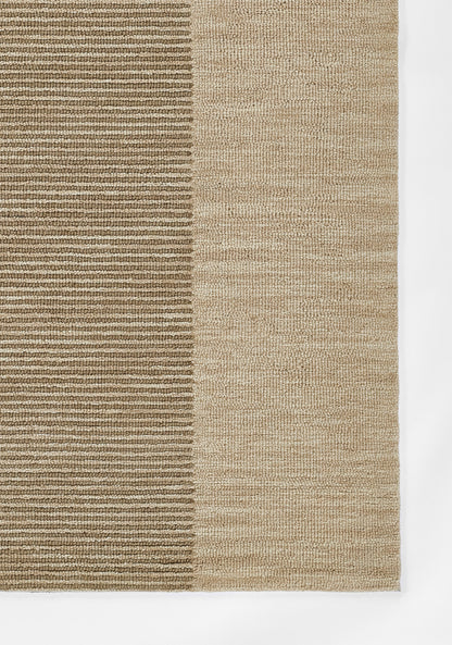 Rectangular jute-style rug with two-tone beige: dark ribbed left half and lighter textured right half.