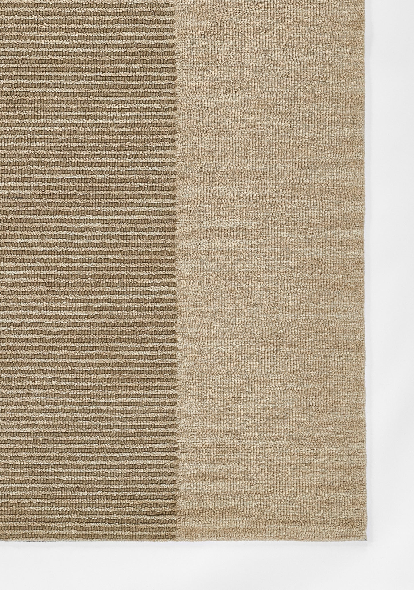 Rectangular natural fiber rug in two-tone beige with ribbed left section and smoother right panel.