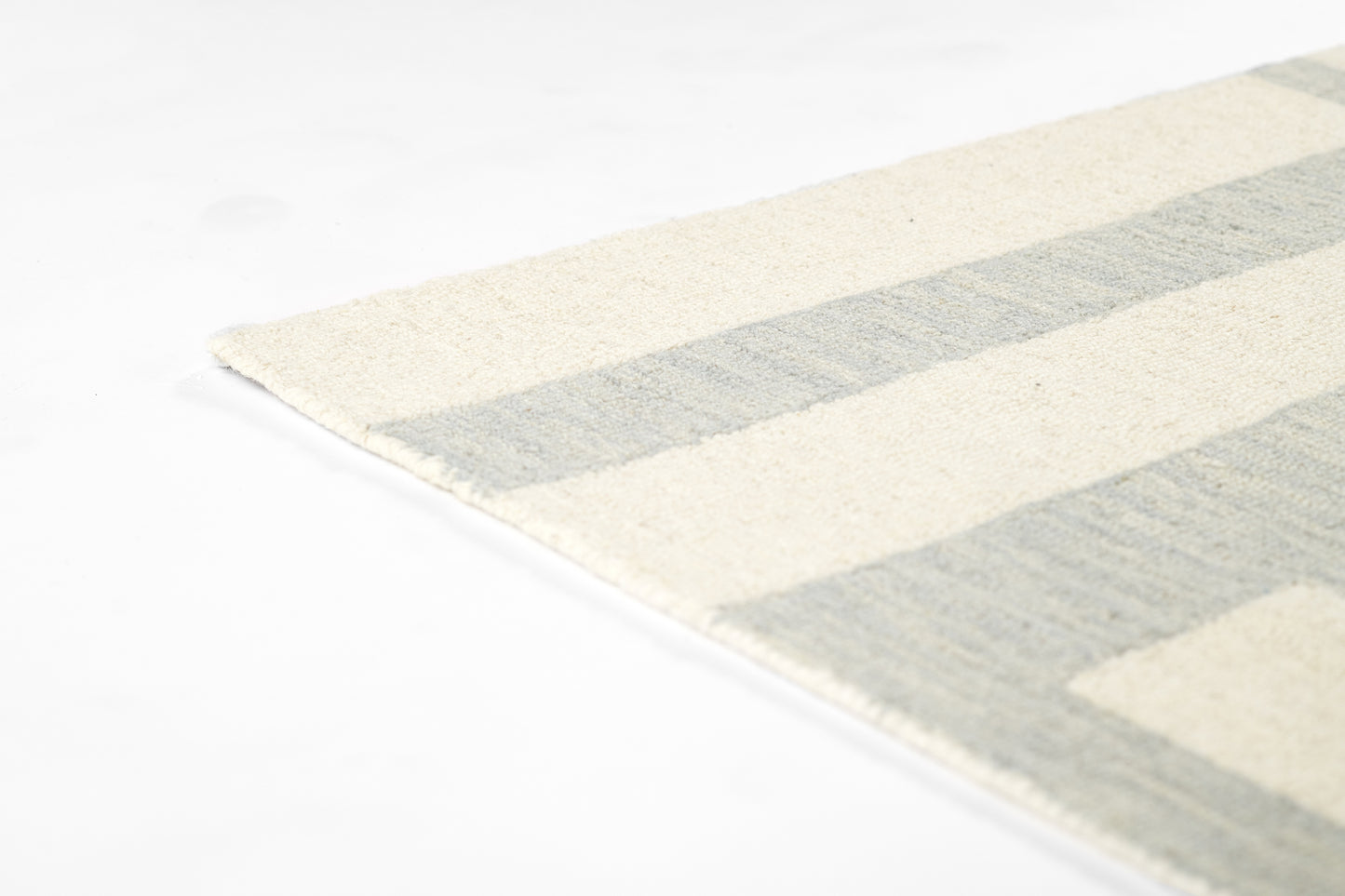 Cream and pale blue-gray striped woven rug with fringed edge, rectangular.