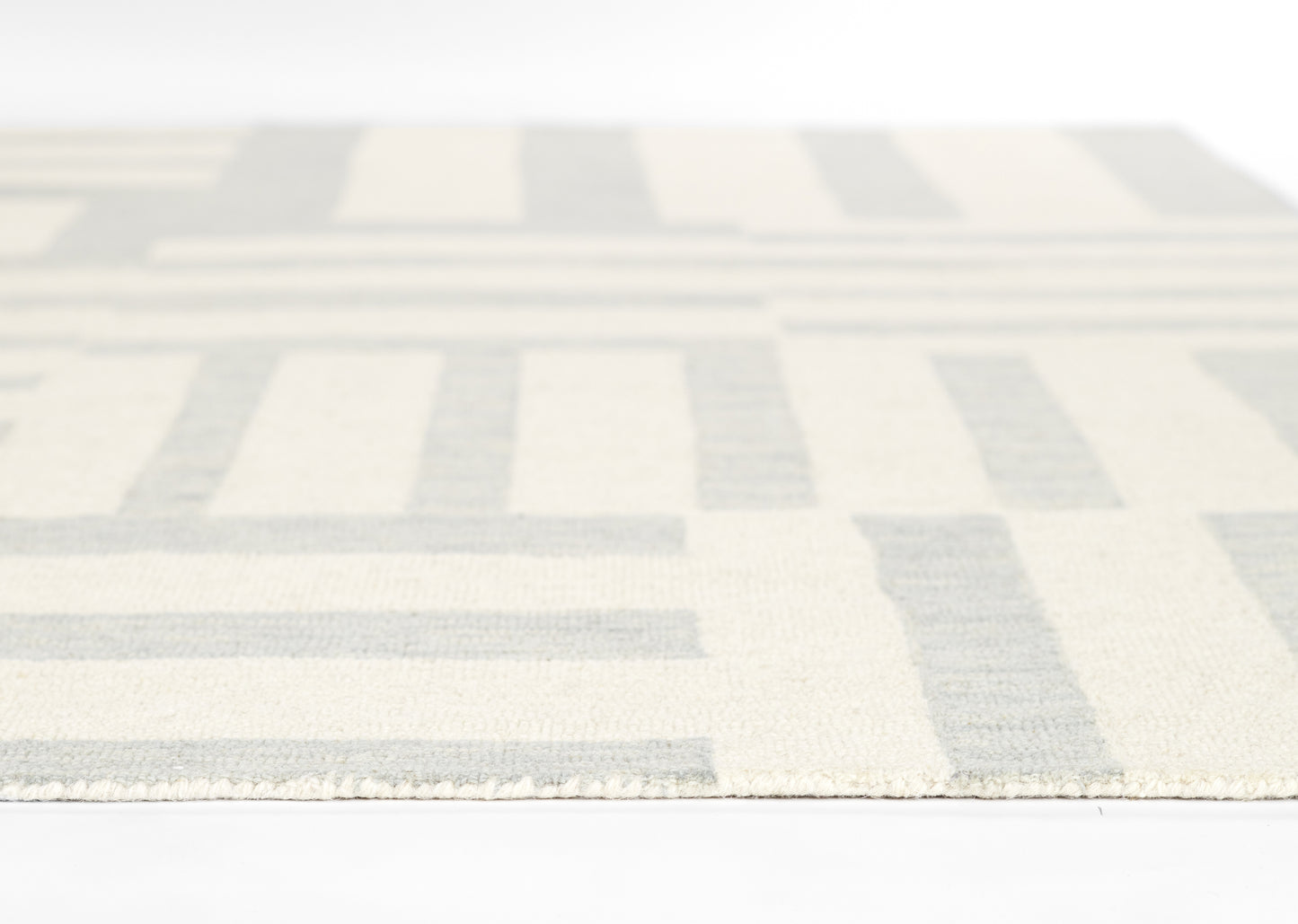 Geometric cream and pale blue rug with rectangular blocks; woven texture for a modern living room.