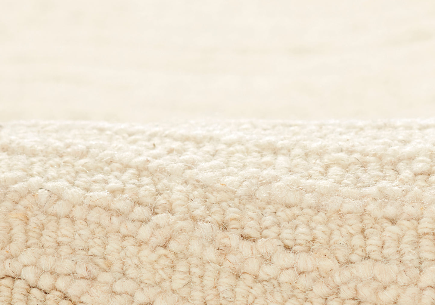 Close-up of beige looped-pile carpet fibers with a soft, fluffy texture for a cozy area rug.