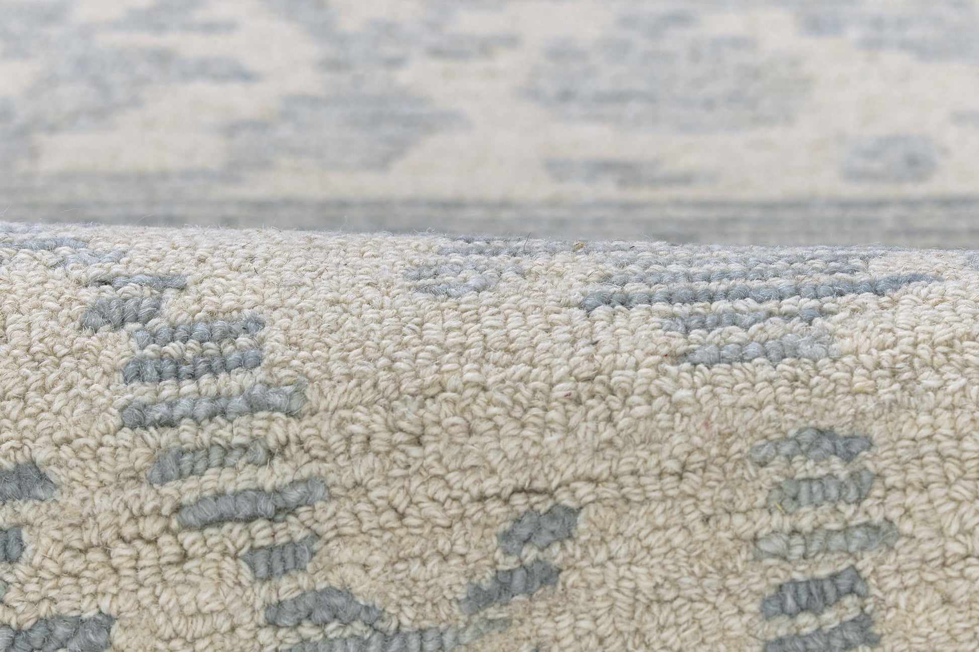 Blue and beige woven area rug with textured loop-pile and abstract pattern.