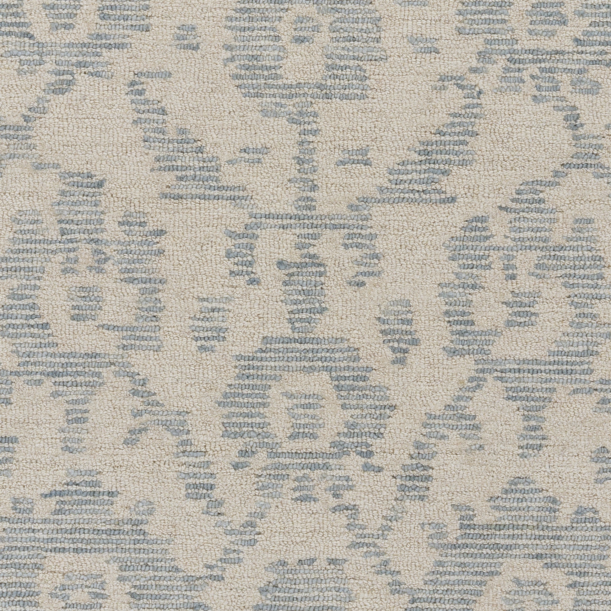 Beige rug with blue damask motif and woven texture.