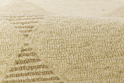 Beige textured rug close-up with loop pile and subtle geometric stepped pattern.