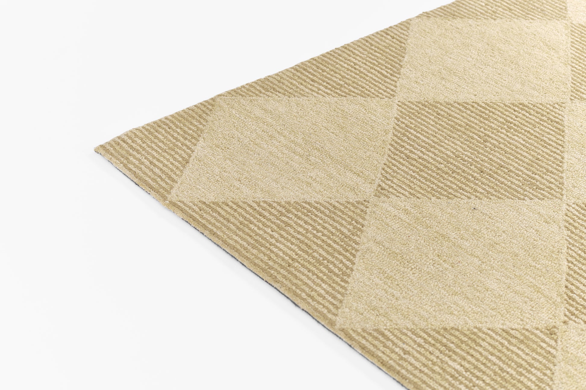 Beige geometric checkered runner rug corner with textured square panels, woven soft tan tones.